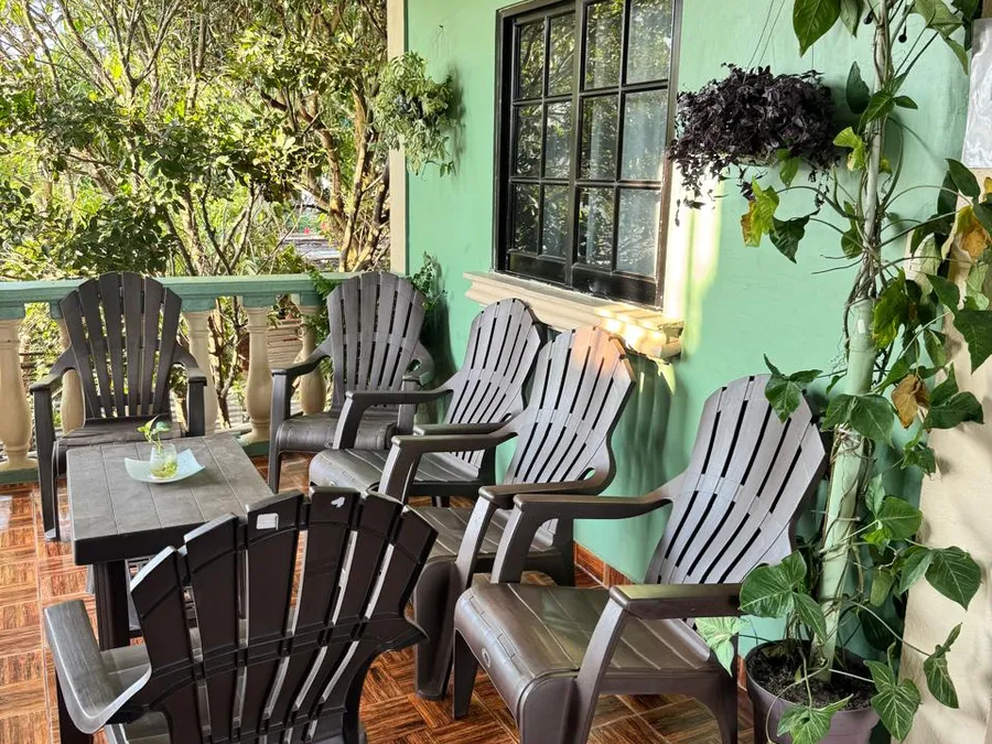 Terraza de Casa de Huéspedes Microhotel con sillones y mesa entre plantas