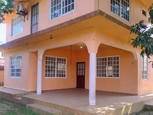 Fachada de dos pisos de Casa Ceci con terraza techada