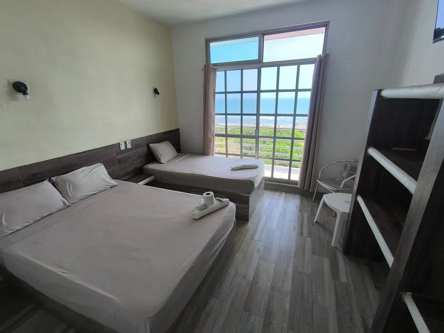 Habitación del Hotel LunAzul con dos camas y ventanal con vista al mar
