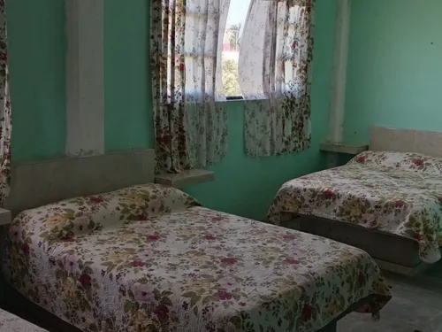 Habitación triple con tres camas y cortinas floreadas en Quinta Ruben's, Tecolutla