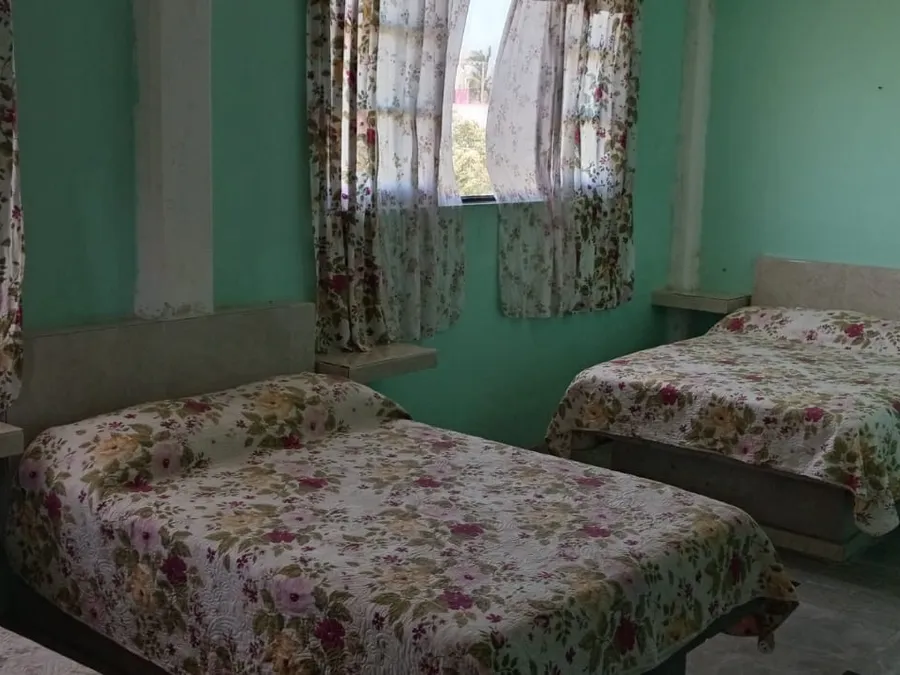 Habitación triple con tres camas y cortinas floreadas en Quinta Ruben's, Tecolutla
