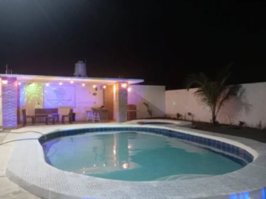 Alberca de Villas Conchita De Mar iluminada de noche con palapa bar
