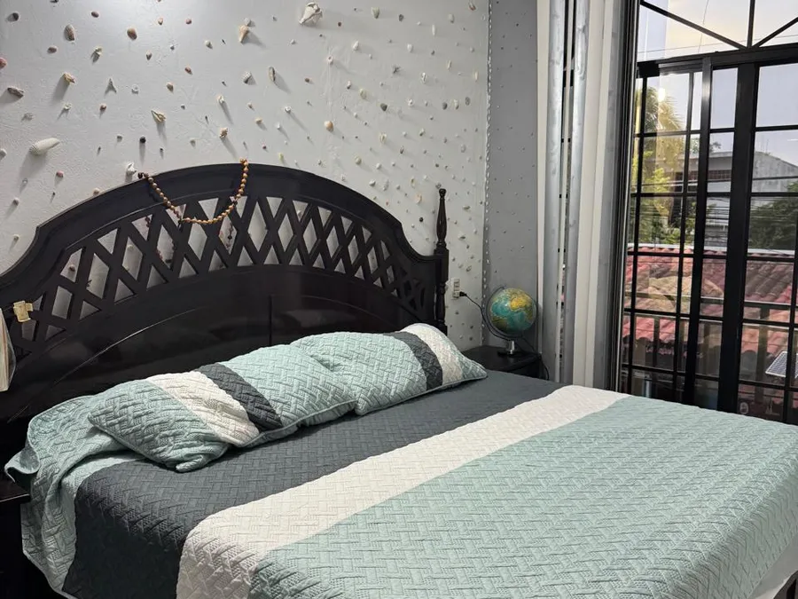Recámara de Casa de Huéspedes Microhotel con cama matrimonial y pared decorada con conchas