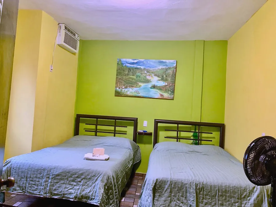 Habitación del Hotel Manglar con dos camas matrimoniales y aire acondicionado