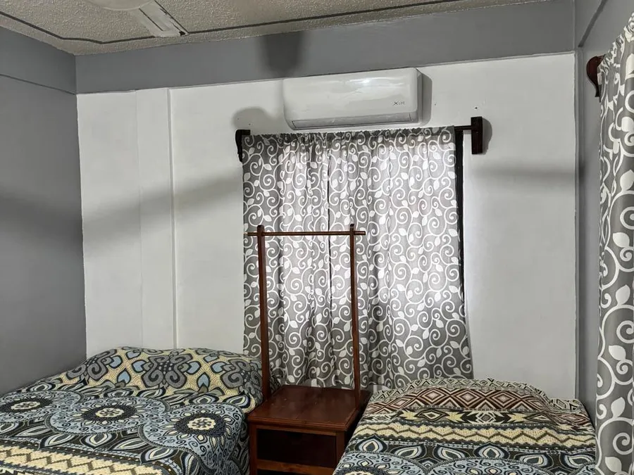 Recámara de Casa de Huéspedes Microhotel con dos camas, ventilador de techo y aire acondicionado