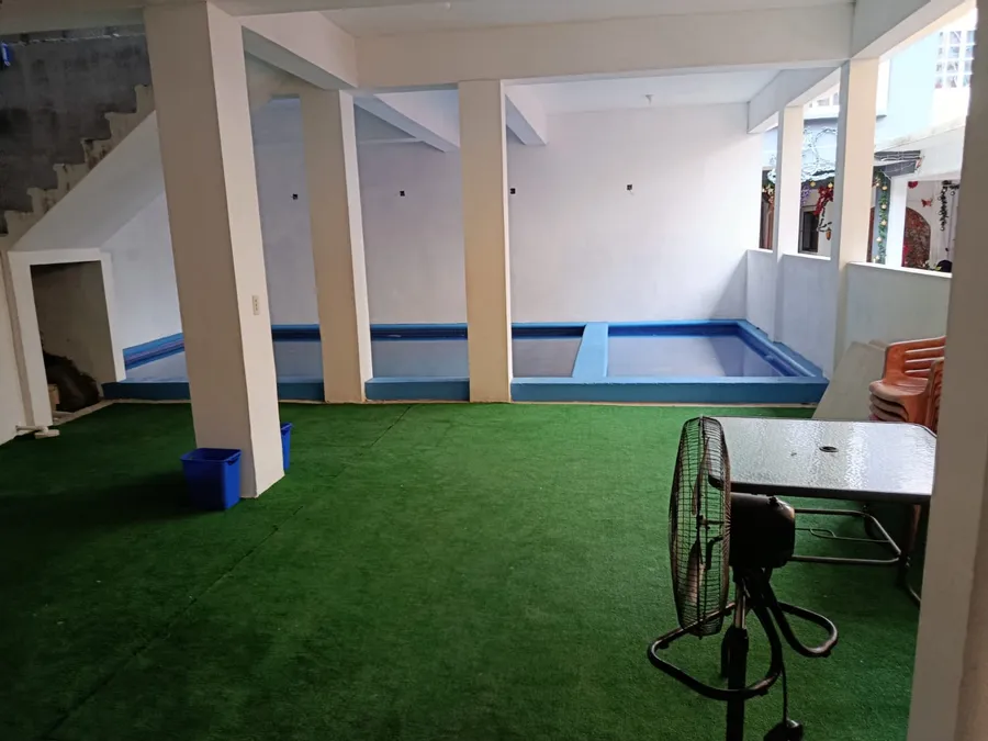 Alberca techada de Hotel El Pariente con área de descanso