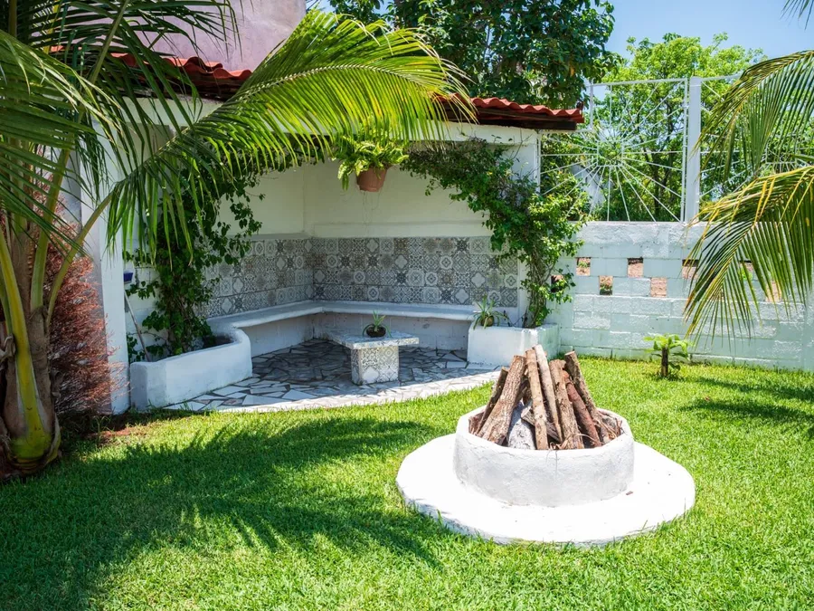 Área de fogata con asientos de mosaico en el jardín de Casa Vacacional Orquídeas