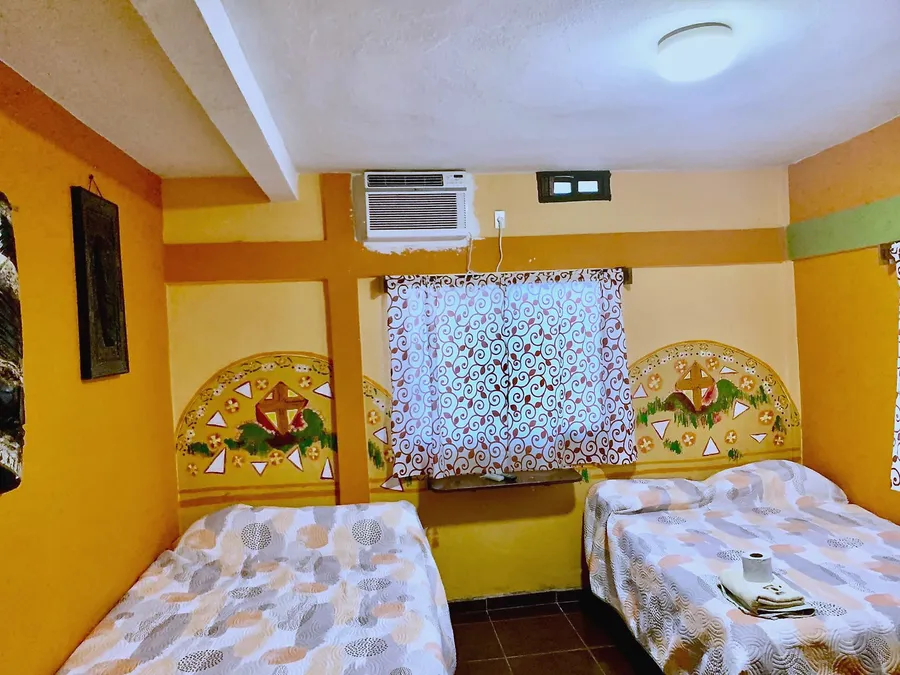 Habitación del Hotel Manglar con cabeceras pintadas a mano y aire acondicionado