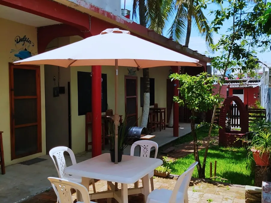 Patio con sombrilla, mesas y jardin de Casa Mandala en Tecolutla