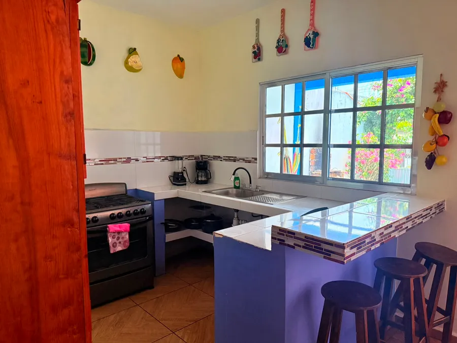 Cocina equipada con estufa y ventana al jardín de Casa Vía Mar en Tecolutla