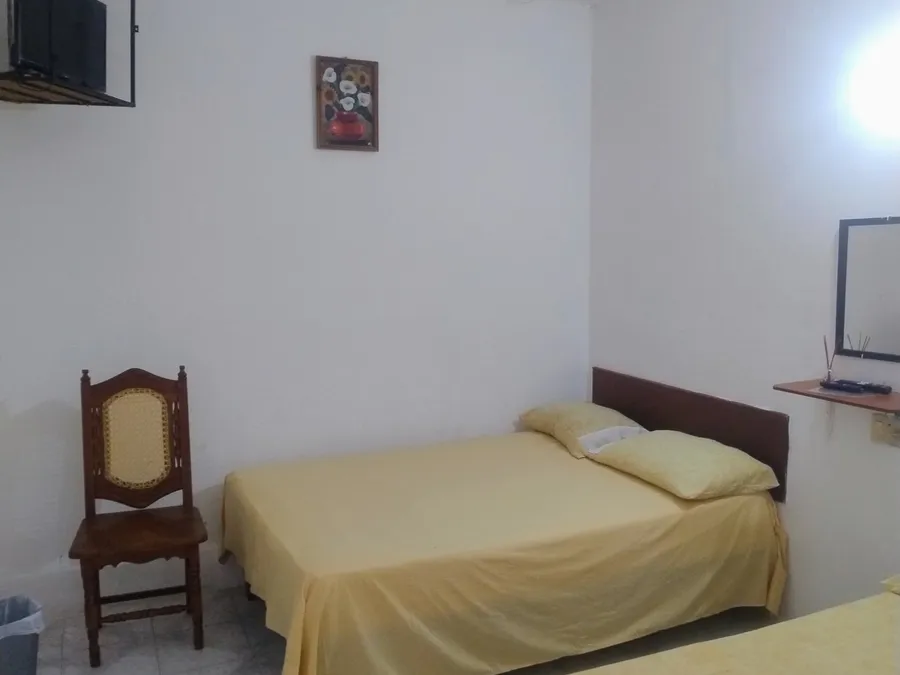 Habitación de Habitaciones Mary con cama matrimonial, ventilador de techo y silla de madera