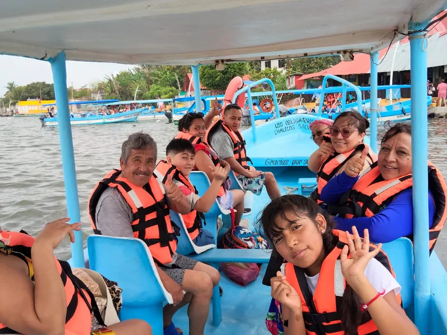 Grupo de turistas sonriendo y saludando a bordo de la Lancha Mi Ángel IR