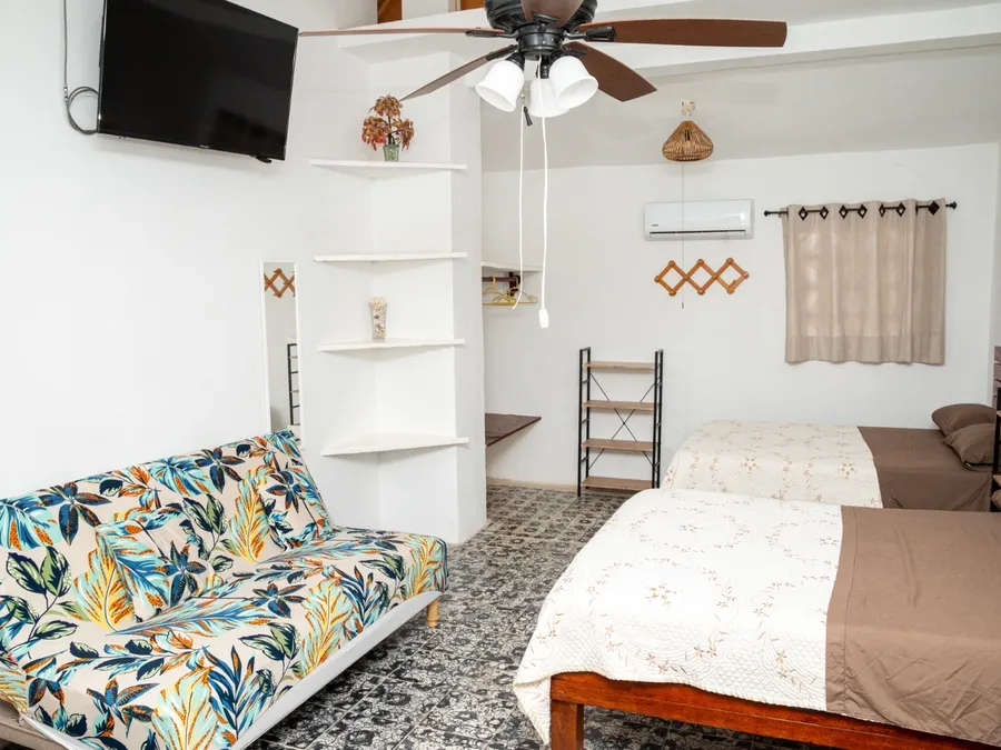 Habitación de Casa Vacacional Orquídeas con sofá cama y televisión