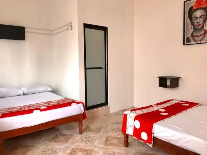 Habitación de Hotel Luna con dos camas y cuadro de Frida Kahlo