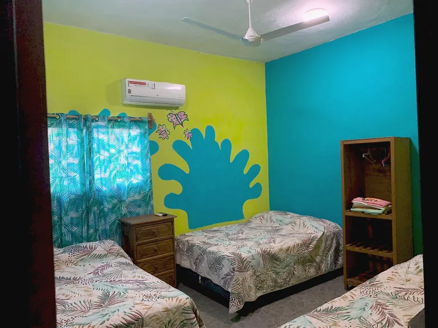 Habitación del Hotel Manglar con mural en la pared y aire acondicionado