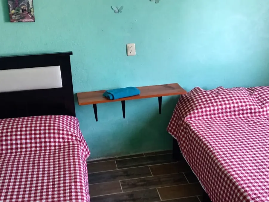 Habitación doble con dos camas y piso de madera en Quinta Ruben's