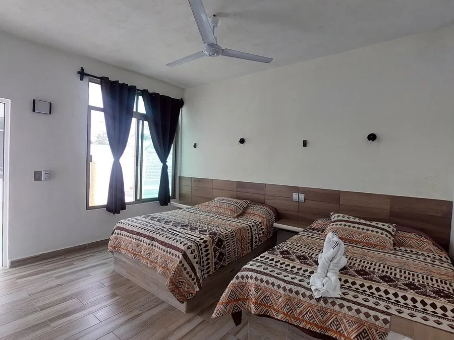Habitación del Hotel LunAzul con dos camas y ventilador de techo