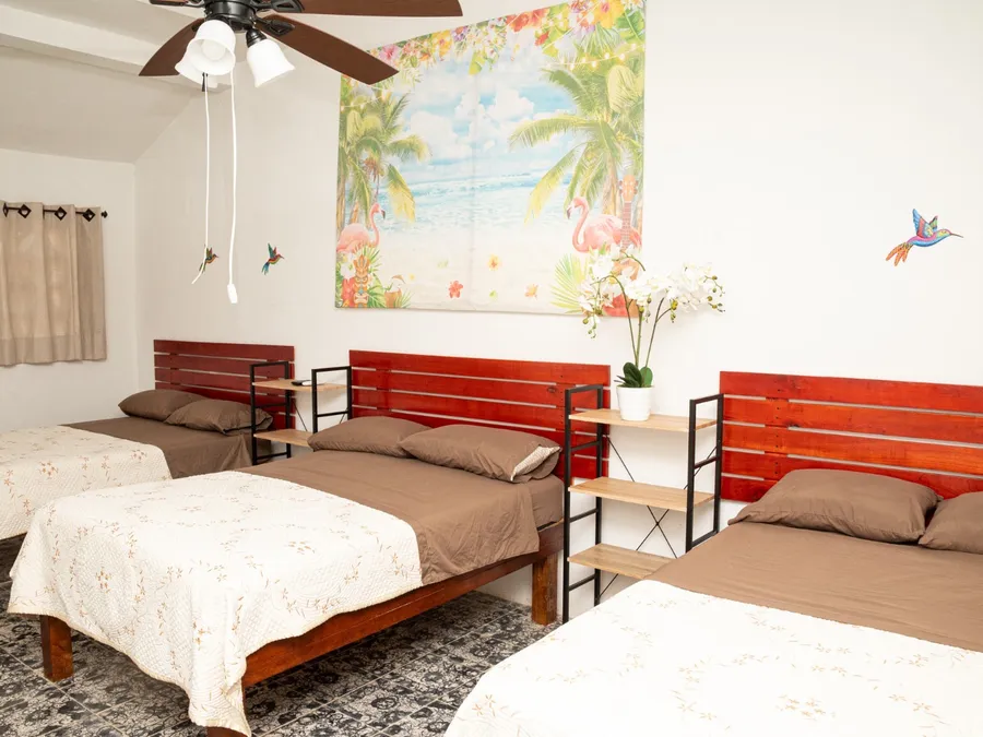 Habitación de Casa Vacacional Orquídeas con tres camas y mural tropical