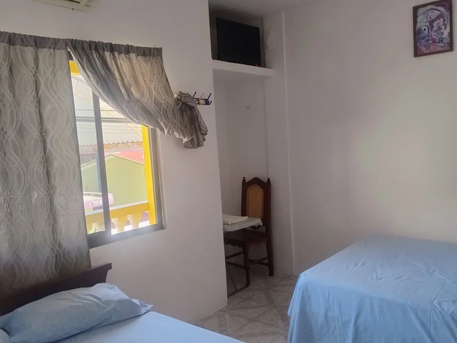 Habitación de Habitaciones Mary con dos camas, aire acondicionado y ventana con cortinas