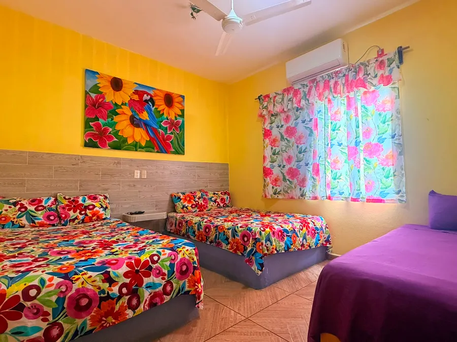 Habitación con dos camas y cuadro de girasoles de Casa Vía Mar en Tecolutla