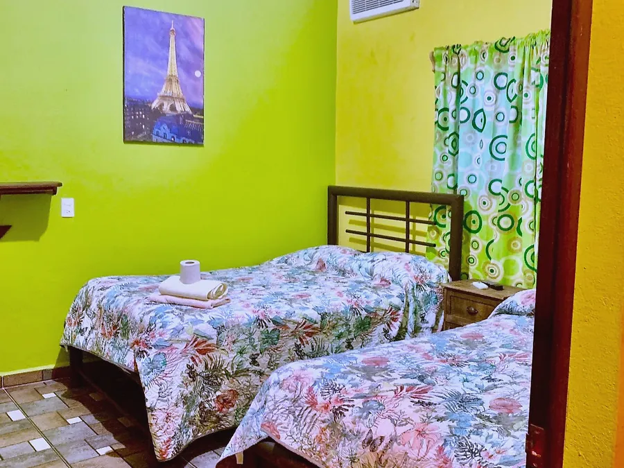 Habitación del Hotel Manglar con dos camas y piso de mosaico
