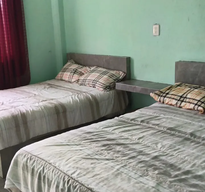 Habitación con dos camas y ventana hacia el jardín en Quinta Ruben's