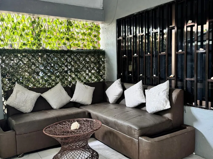 Sala de estar en la terraza de Casa de Huéspedes Microhotel con sillón de piel y cojines