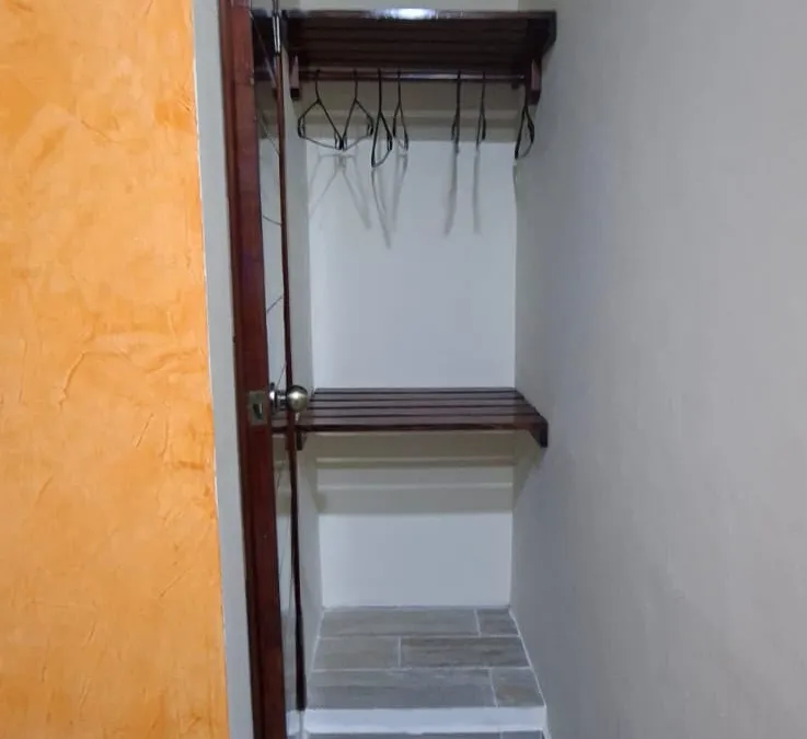 Clóset con ganchos y repisas en las habitaciones de Casa Llanos en Tecolutla