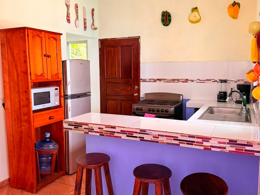 Barra de cocina con bancos de madera de Casa Vía Mar en Tecolutla
