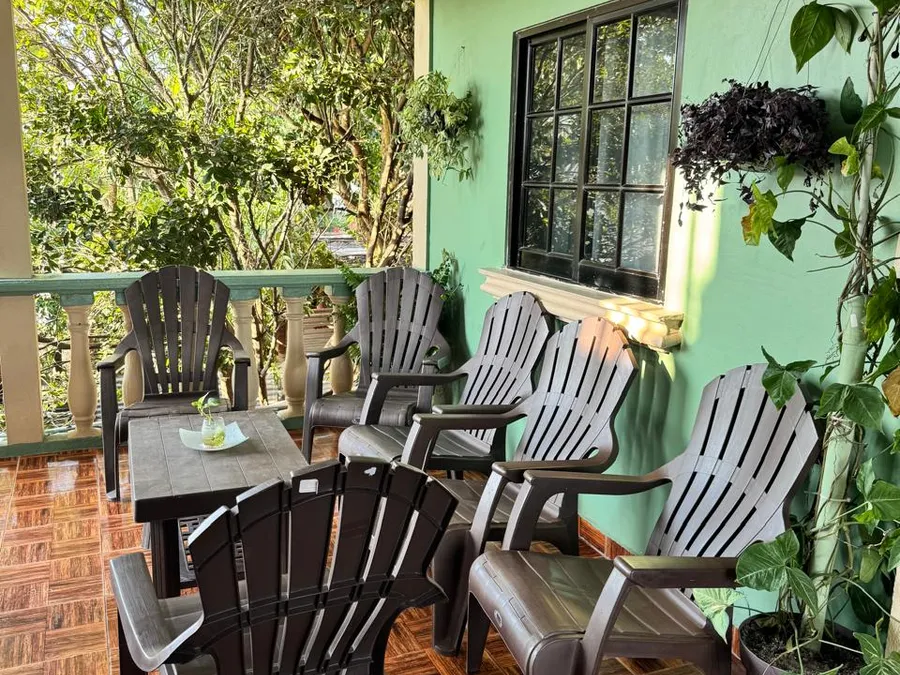 Terraza de Casa de Huéspedes Microhotel con sillones frente a la pared verde