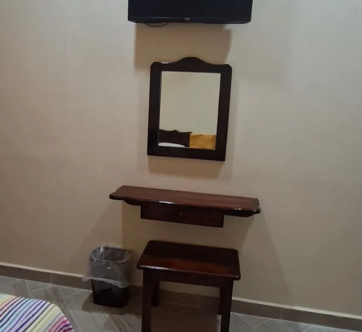 Televisión, espejo y tocador en las habitaciones de Casa Llanos en Tecolutla